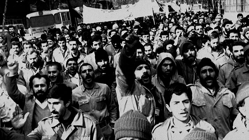 Des Iraniens manifestent dans une rue de Téhéran, le 15 février 1989, scandant des slogans "A bas la Grande-Bretagne et à bas l'Amérique," pour protester contre la publication au Royaume-Uni des « Versets sataniques »