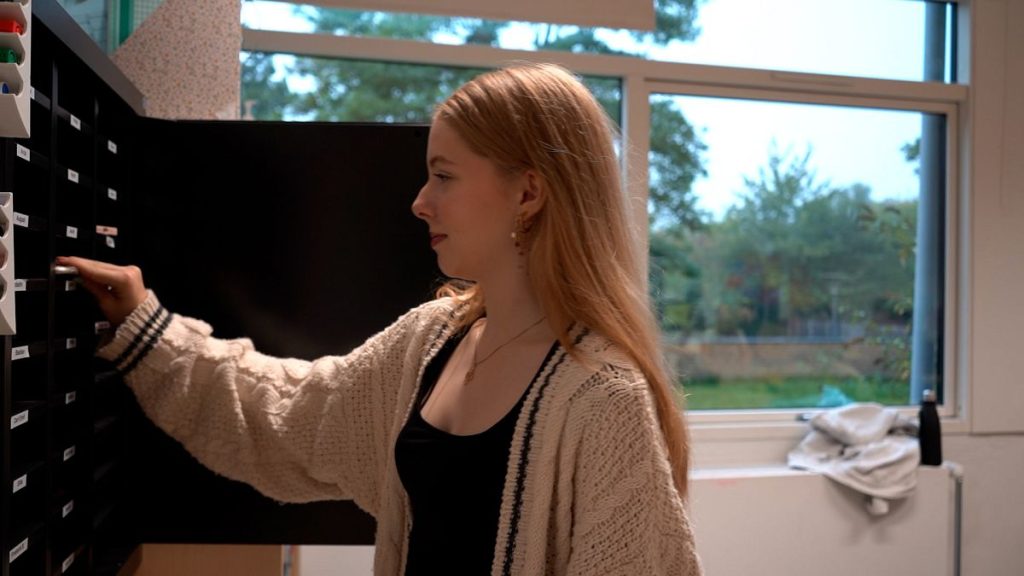 A pupil at Trongårdsskole leaving her smartphone in the safe before the first lesson.