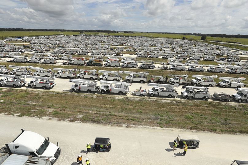 Les monteurs de lignes se rassemblent devant des centaines de camions utilitaires organisés mardi dans les villages de Floride en préparation à l'ouragan Milton