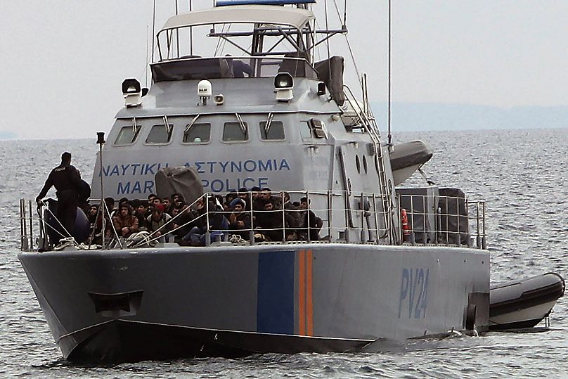 Des migrants à bord d'un bateau de patrouille de la police maritime chypriote alors qu'ils sont amenés dans un port après avoir été secourus,