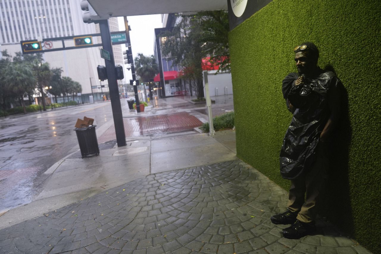 Melvin Lee HIcks, sans abri, porte un sac poubelle pour se protéger de la pluie poussée par le vent, alors qu'il se tient dans une rue du centre-ville de Tampa.