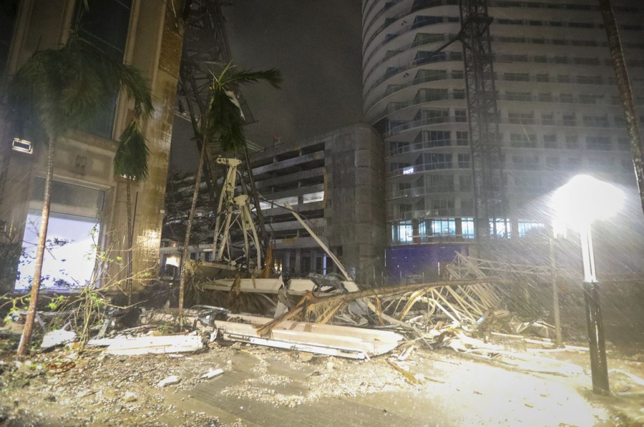 Des débris recouvrent le sol près d'une grue tombée sur un bâtiment le long de la 1ère Avenue Sud à Saint-Pétersbourg, en Floride.