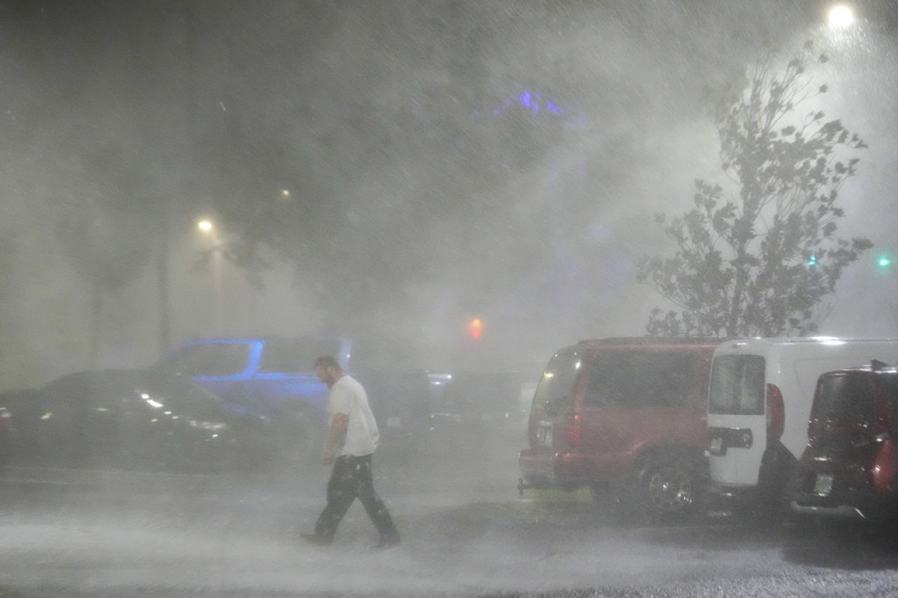 Max Watts, de Buford, en Géorgie, se promène dans le parking pour vérifier une caravane garée devant l'hôtel où il traverse l'ouragan Milton avec des collègues.