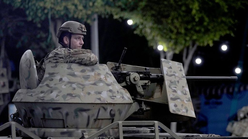 FILE: A Lebanese army soldier sits behind his weapon atop of an APC at the site of an Israeli airstrike in Beirut