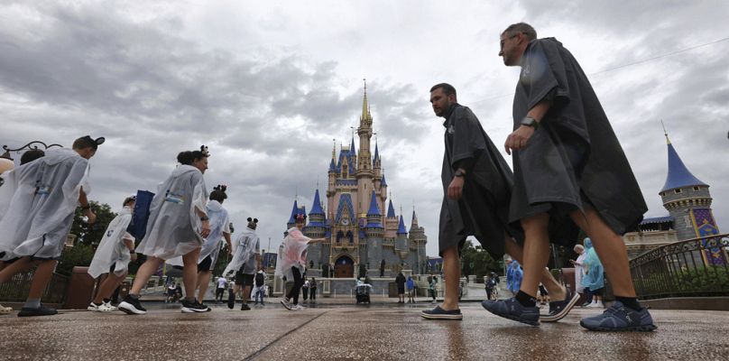 Les invités résistent aux premières bandes de pluie de l'ouragan Milton au Magic Kingdom de Walt Disney World avant la fermeture du parc