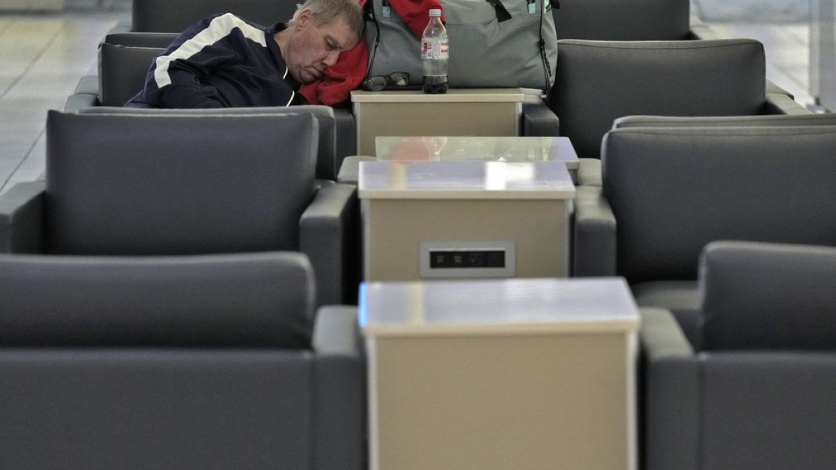 Travel chaos: A passenger sleeps at the Tampa International Airport on Tuesday after most flights were canceled due to the arrival of Hurricane Milton