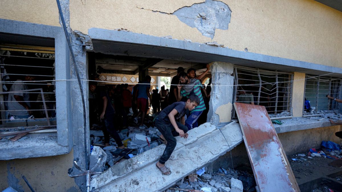 Palestinians search for the bodies of their relatives killed in an Israeli bombardment of a school in Deir al-Balah, central Gaza Strip.