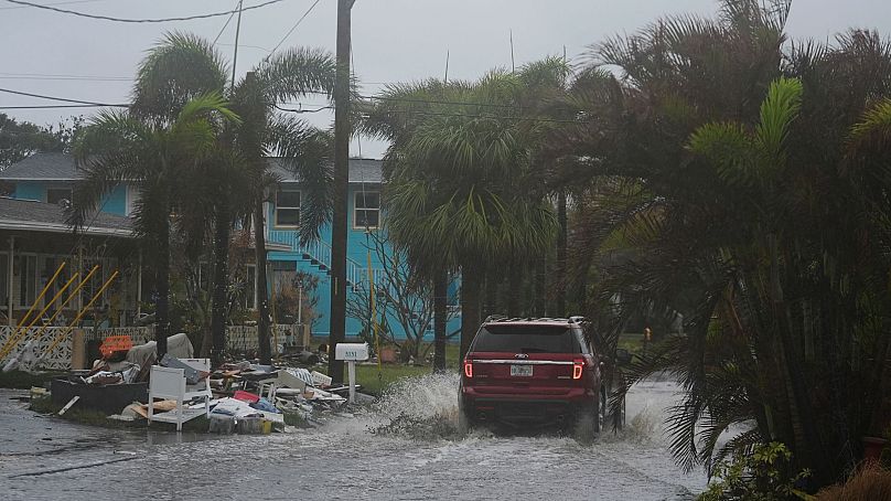 Une voiture traverse les inondations causées par l'ouragan Helene, le long d'une rue qui avait déjà commencé à être inondée à cause de la pluie avant l'ouragan Milton, à Gulfport, en Floride, le 9 octobre 2024. 