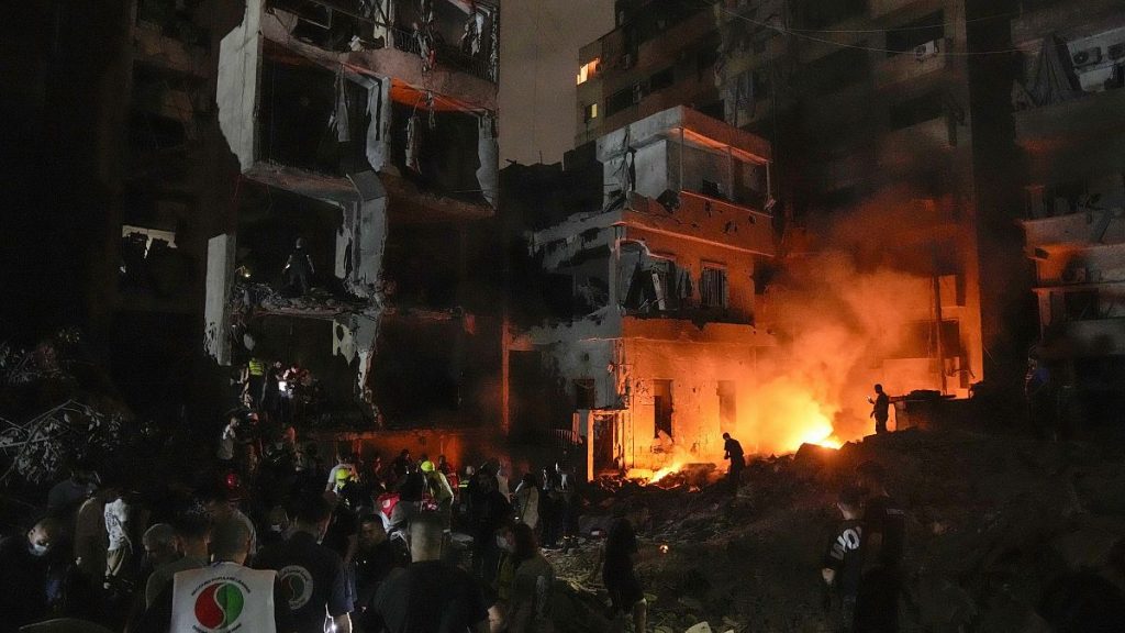 People gather in front of destroyed buildings hit by an Israeli airstrike in central Beirut, 10 October, 2024