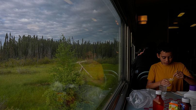 Un passager prend son petit-déjeuner alors qu'un train circule le vendredi 9 août 2024, près d'Ilford, au Manitoba. 