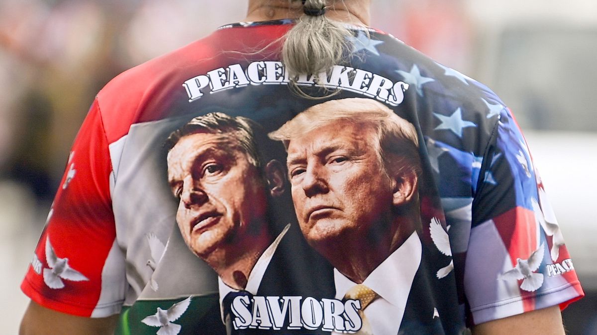 A man sports a shirt with the faces of Prime Minister of Hungary Viktor Orbàn, left, and Donald Trump as he participates in a march, in Budapest, 1 June 2024