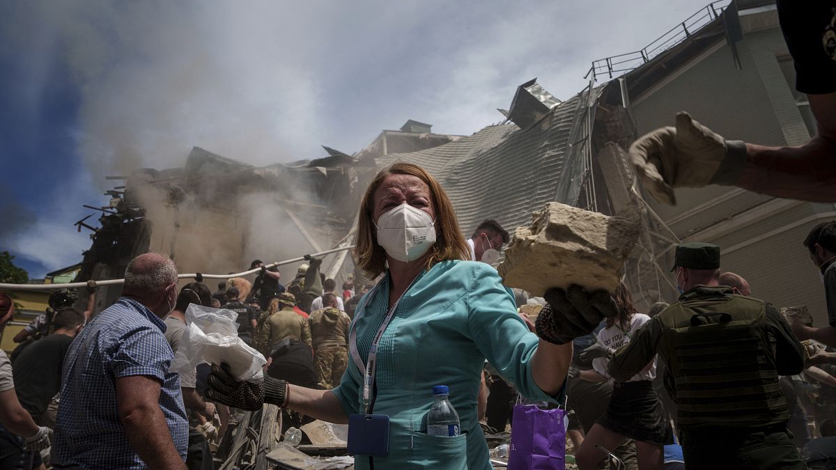 Emergency workers remove rubble and look for survivors at the site of Okhmatdyt children