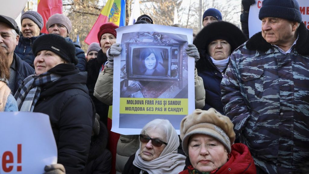 A woman holds a banner showing the country