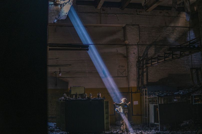 Un soldat ukrainien à l'intérieur de l'aciérie Azovstal en ruine se tient sous un rayon de soleil dans son abri à Marioupol, le 7 mai 2022.