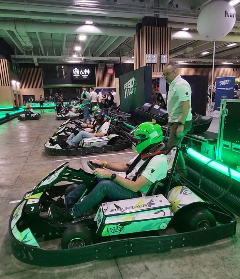 Les participants du Mondial de l'Automobile de Paris 2024 testent le Speed2Max, un kart écologique. 