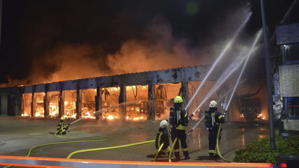 Firefighters try to extinguish a fire in a vehicle depot in Stadtallendorf, Germany, Wednesday Oct. 16, 2024.