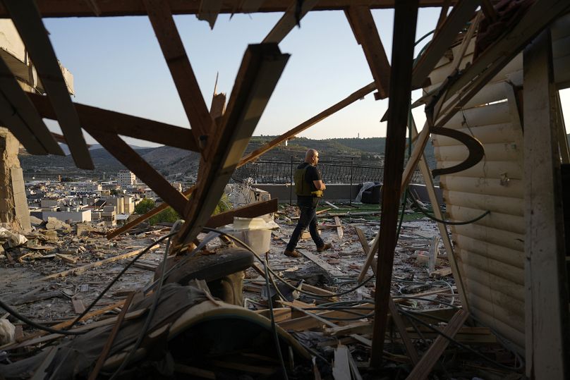 Les forces de sécurité israéliennes inspectent les dégâts causés à une maison touchée par une roquette tirée depuis le Liban sur la ville de Majd al-Krum, le 16 octobre 2024.