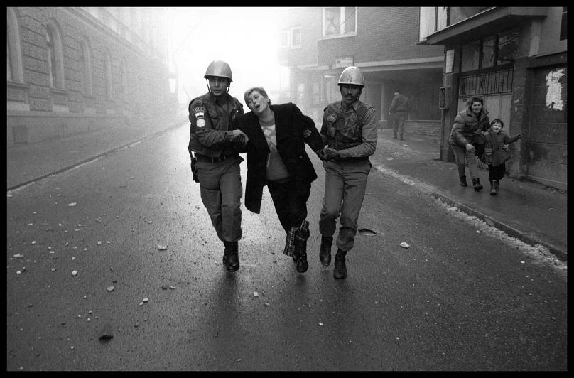 Des soldats égyptiens des forces de maintien de la paix des Nations Unies aident une femme blessée fuyant les lieux d'une explosion à Sarajevo, en Bosnie-Herzégovine, au cours de l'hiver 1994.