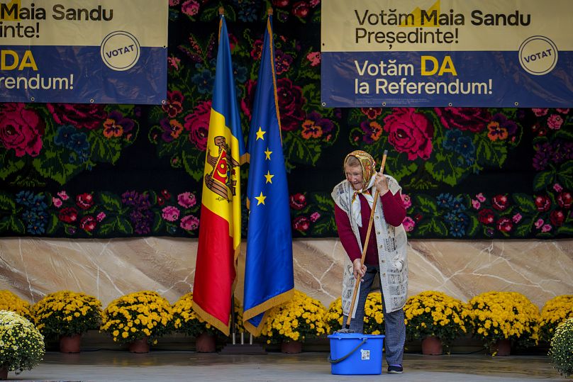 Une femme nettoie la scène avant un rassemblement électoral de la présidente moldave Maia Sandu à Măgdăceşti, le 17 octobre 2024.