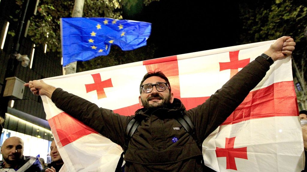 A man holds a Georgian flag during an opposition rally in Tbilisi, 20 October, 2024