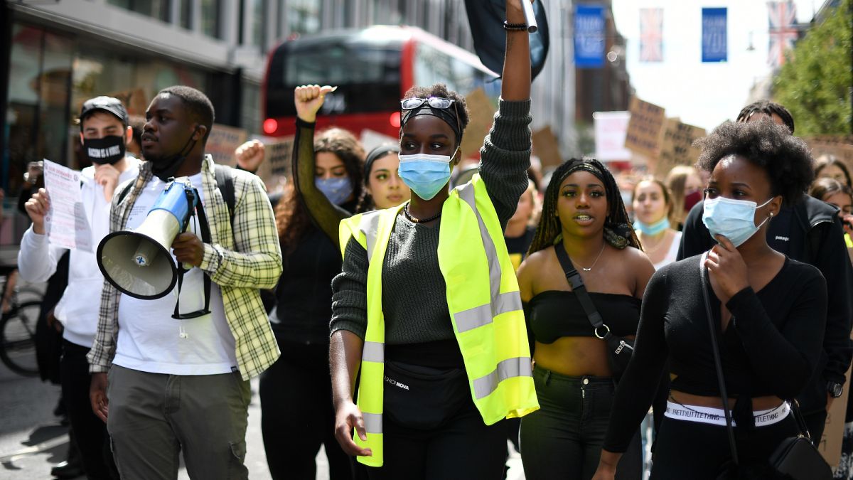 People, some wearing protective masks against the spread of coronavirus, chant slogans, during a march organised by Black Lives Matter, in London, Sunday, June 21, 2020.