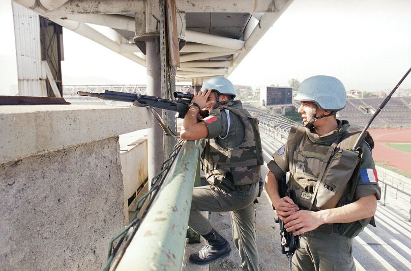 Deux casques bleus français de l'unité anti-sniper observent les lignes d'affrontement depuis leurs positions dans le stade olympique de Sarajevo, le 27 septembre 1994.