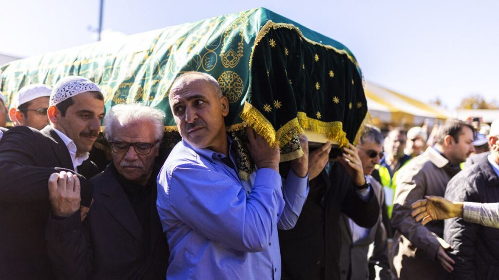 Pall-bearers carry the casket into the stadium