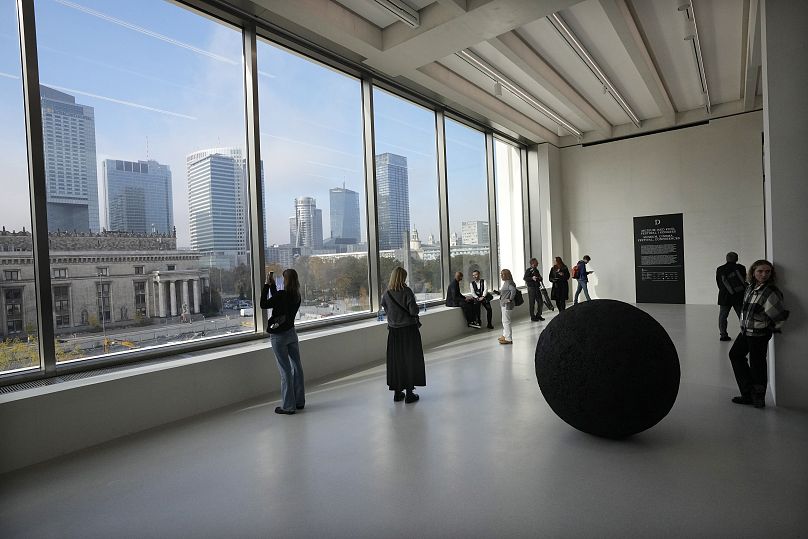 Des gens regardent par la fenêtre du Musée d'art moderne de Varsovie, en Pologne, le jeudi 24 octobre 2024.