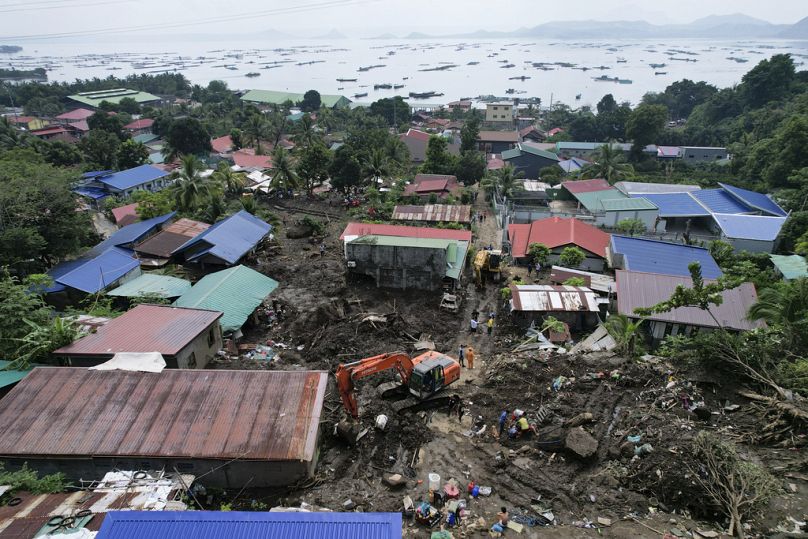 Les sauveteurs recherchent des corps sous les décombres après qu'un glissement de terrain déclenché par la tempête tropicale Trami a frappé des maisons, faisant plusieurs morts parmi les villageois à Talisay, le 26 octobre 2024.