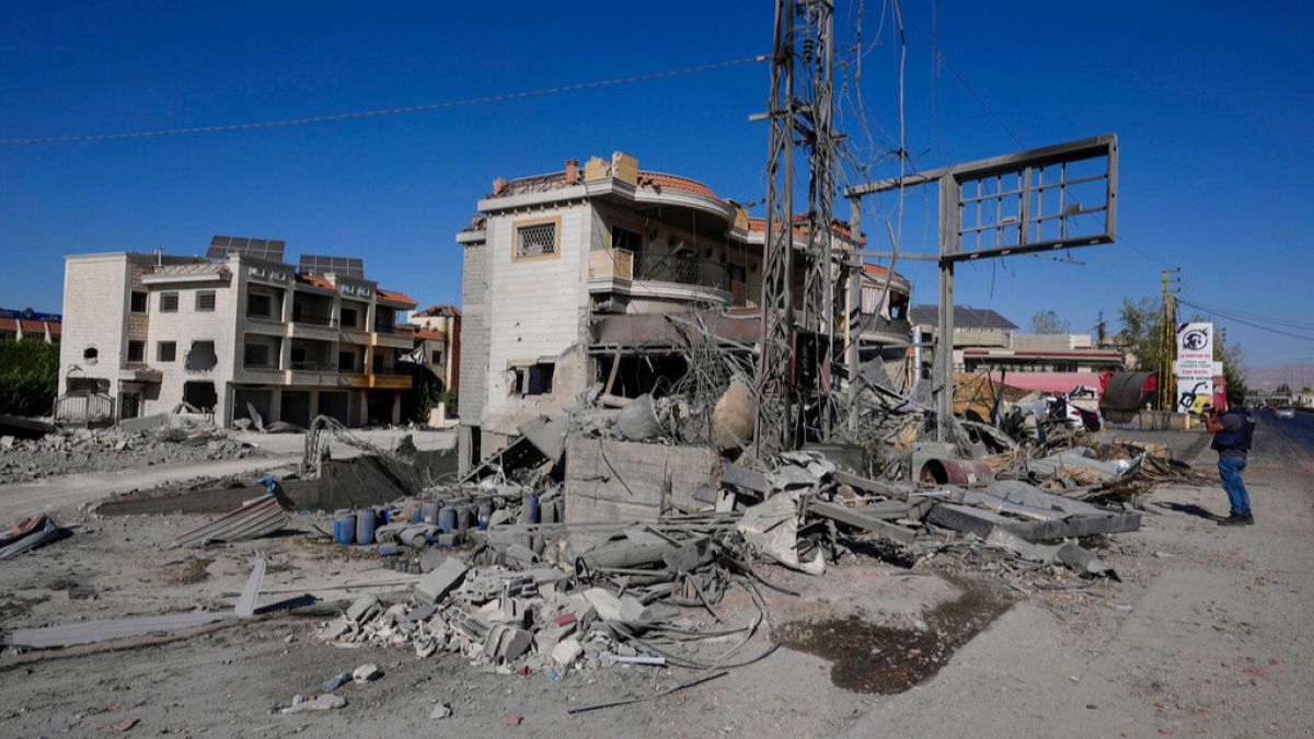 A journalist documents the damaged buildings at the site of an Israeli airstrike, in the village of Temnin, Bekaa Valley, eastern Lebanon, Saturday, Oct. 5, 2024.