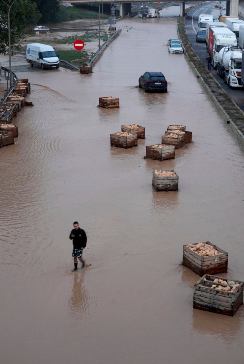 Un homme marche sur une autoroute inondée à Valence