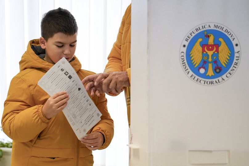 Un enfant se rend en famille au bureau de vote