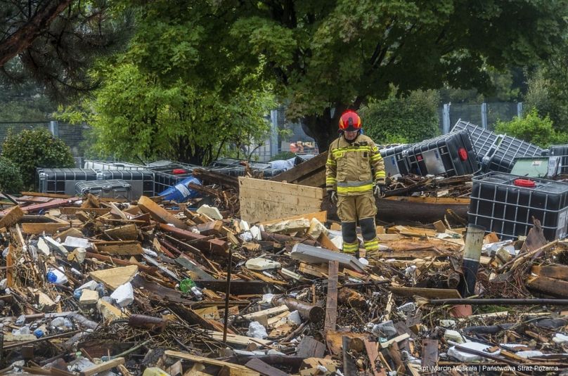 Cette photo fournie par les pompiers polonais montre des pompiers en train de retirer des tas de débris déversés dans les rues par de fortes vagues de crue.