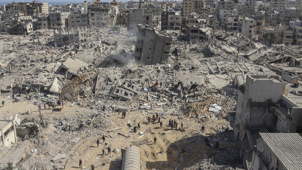 Palestinians walk through the destruction left by the Israeli air and ground offensive on the Gaza Strip.