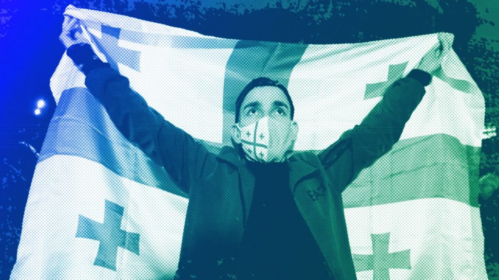 A man holds a Georgian flag during an opposition protest against the results of the parliamentary election in Tbilisi, 28 October 2024