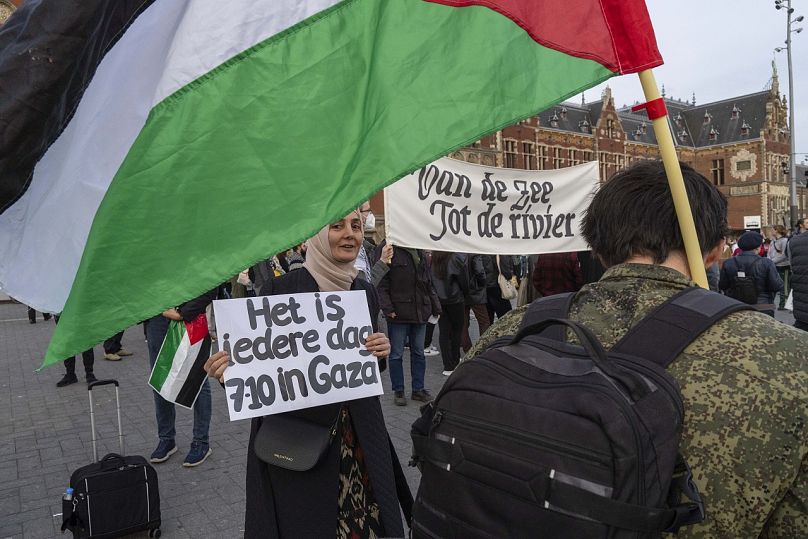 Un manifestant pro-palestinien tient une pancarte en train de lire 