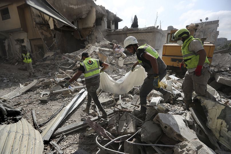 Des secouristes transportent les restes des personnes tuées sur le site touché par les frappes aériennes israéliennes dans le village de Qana, le 16 octobre 2024.