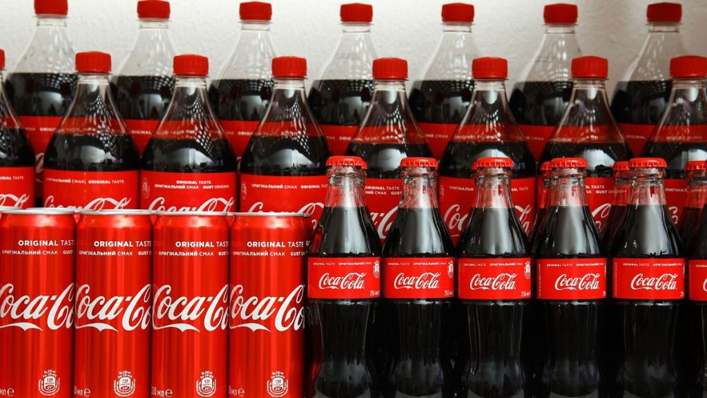 Coca-Cola cans and bottles on display on a store shelf