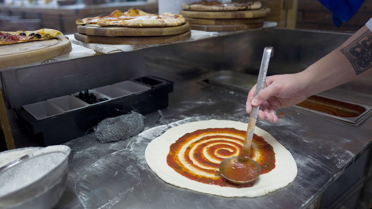 FILE: an employee prepares pizza at a restaurant, 26 January 2017