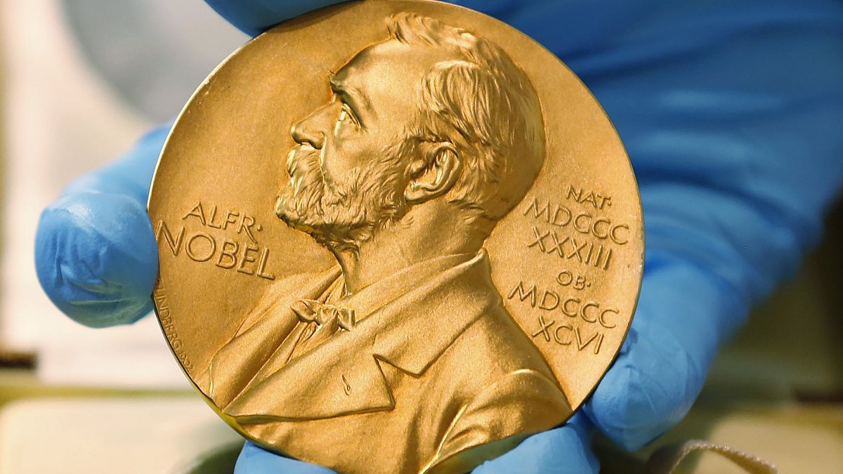 A national library employee shows a gold Nobel Prize medal.