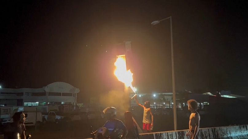 Des manifestants ont incendié un panneau routier devant l'aéroport de Fort-de-France en Martinique, le 11 octobre 2024.