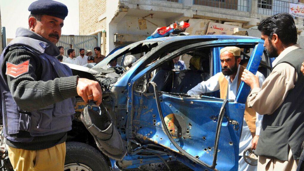 Pakistani police officer examines a police vehicle damaged in a bomb explosion in Quetta, Pakistan on Sunday, March 21, 2010.