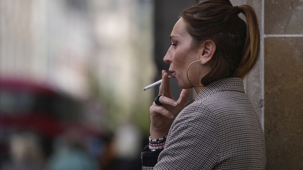 A woman smokes on a London street in April 2024.