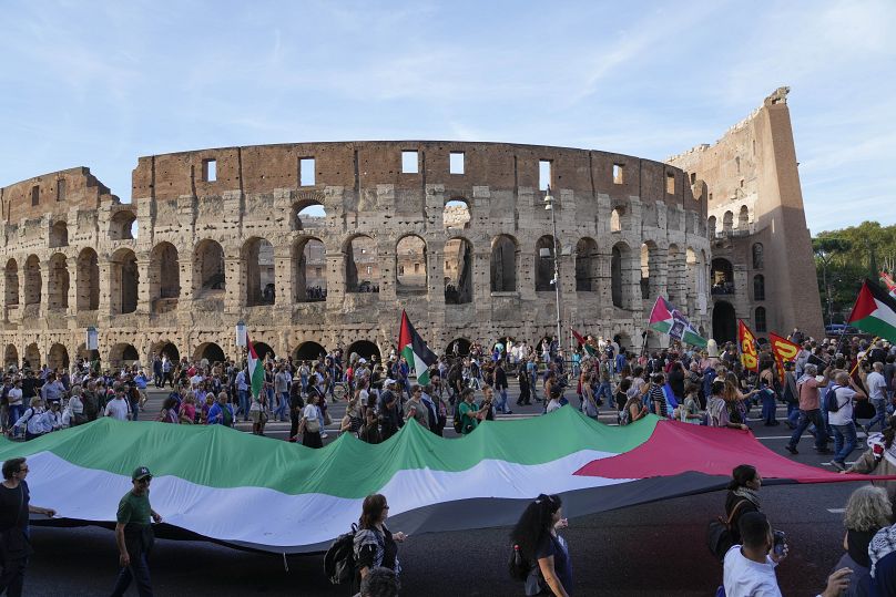 Des gens passent devant le Colisée lors d'un rassemblement pro-palestinien à Rome, le 12 octobre 2024.