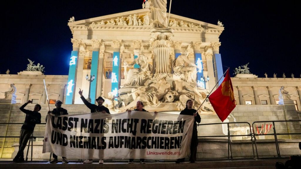 Anti right wing protesters shout slogans and hold an banner that reads "Don