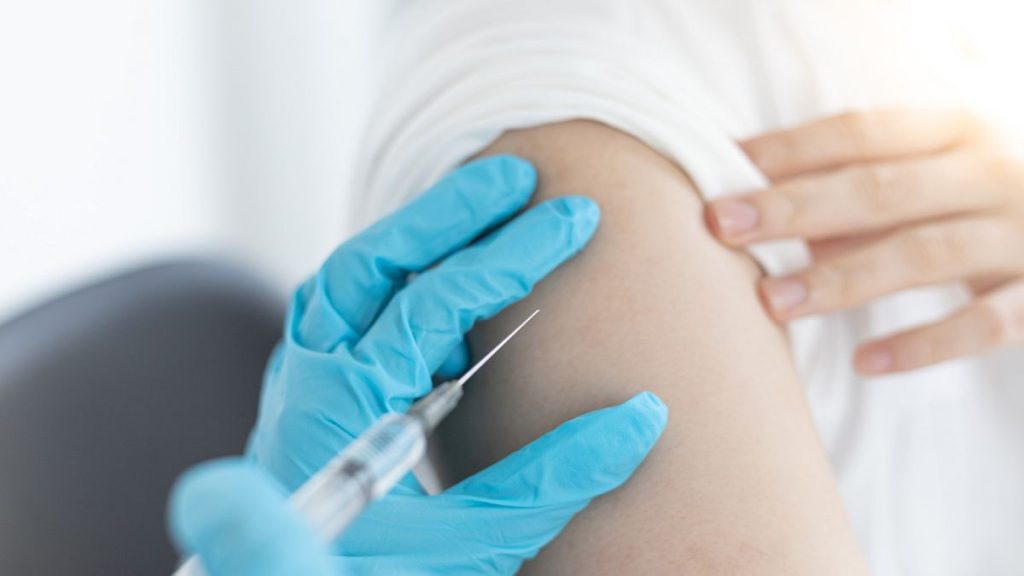 A woman receives a vaccine.