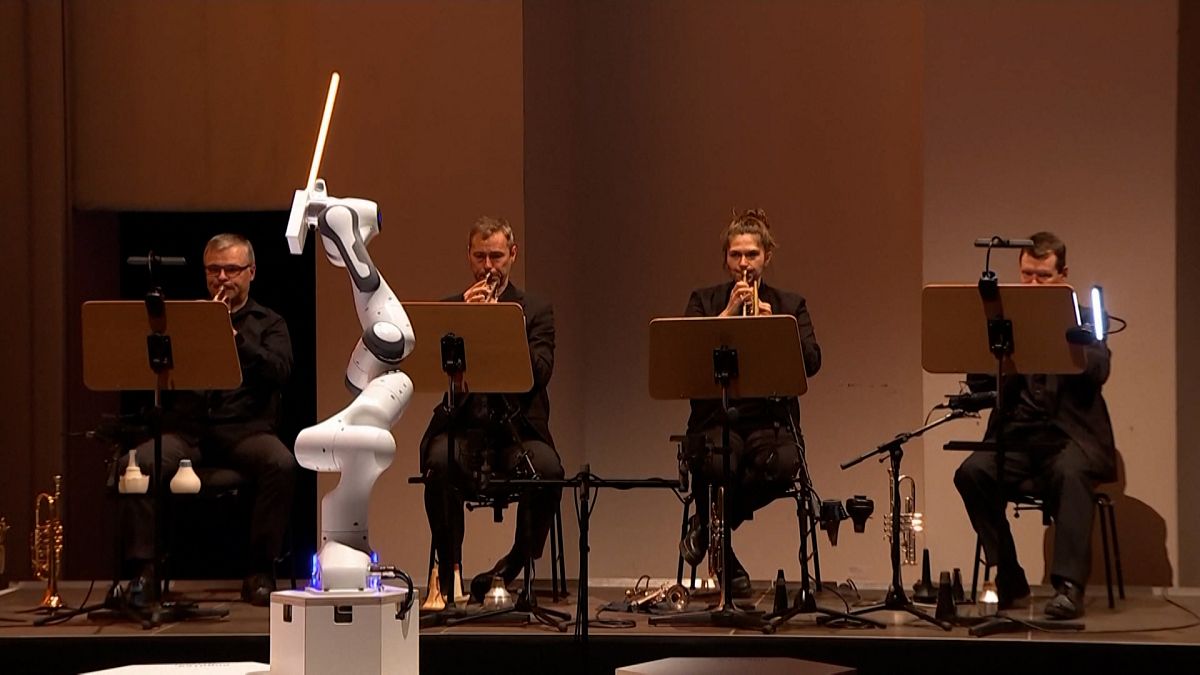 A robot conducts performers of the Dresden Symphony Orchestra as they perform