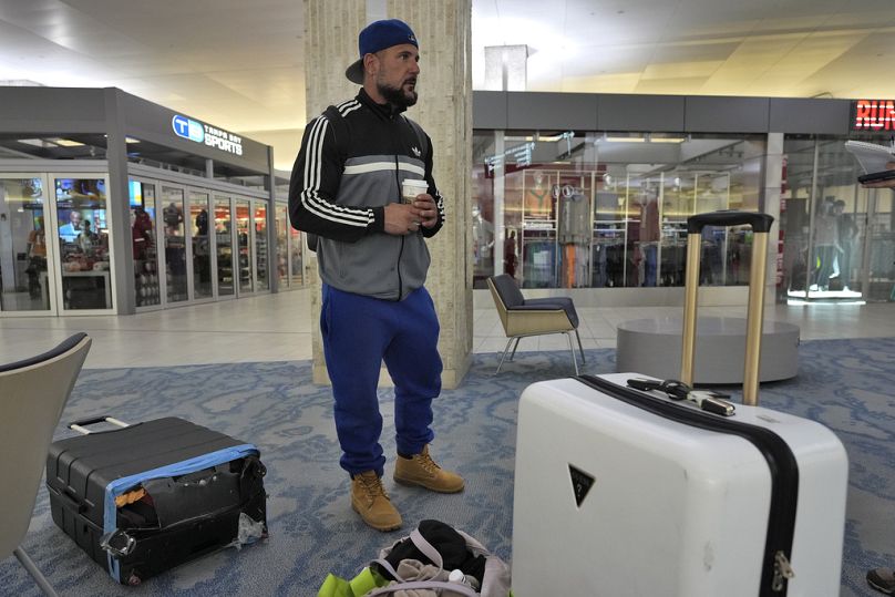 Un passager attend une aide au transport pour se rendre dans un refuge après l'annulation de son vol mardi à l'aéroport international de Tampa.