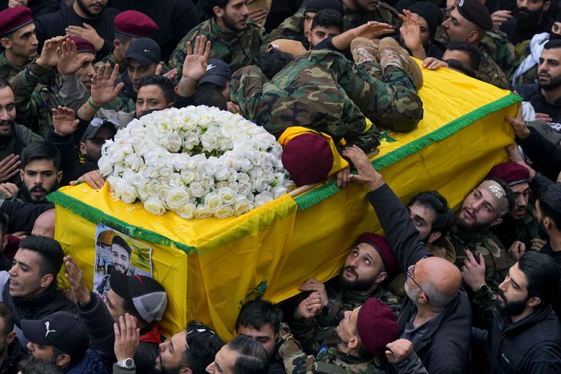 Hussein, frère du combattant du Hezbollah Ali Hassan al-Atat, est allongé sur le cercueil de son frère lors de son cortège funèbre dans le sud de Beyrouth, décembre 2023