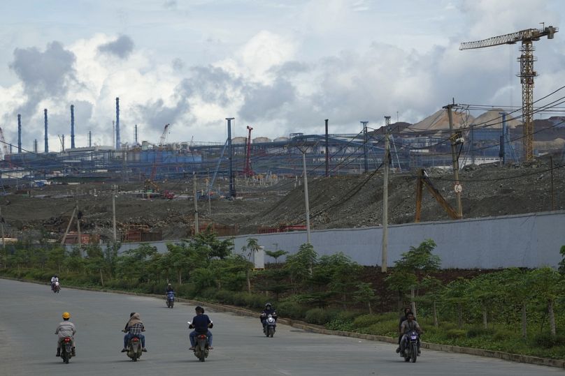 Les automobilistes passent devant le complexe du parc industriel indonésien Weda Bay, dans le centre de Halmahera, dans le nord des Moluques, juin 2024